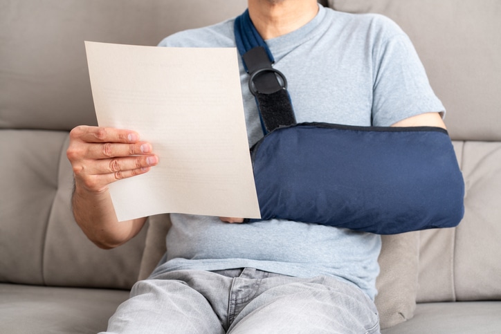 Reading letter about Injury and man compensation paperwork, insurance, legal contract or lawyer consulting. Disability people, attorney or advocate in negotiation, policy advice or accident report closeup